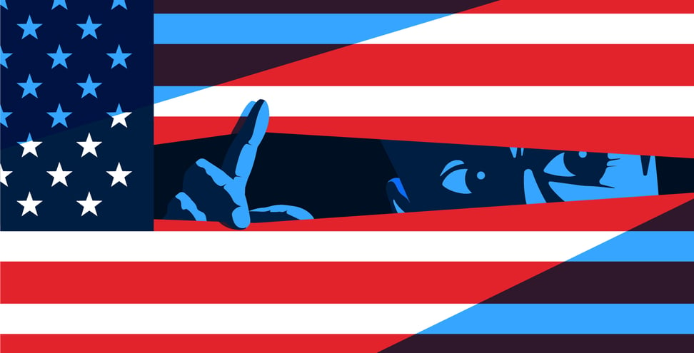 A red white and blue American flag with a cartoon type blue man peaks through the middle of the flag and looks towards the right.