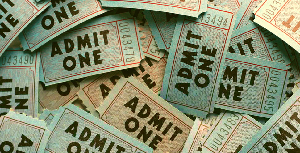 A close-up view of a pile of blue tickets, each labeled "Admit One"